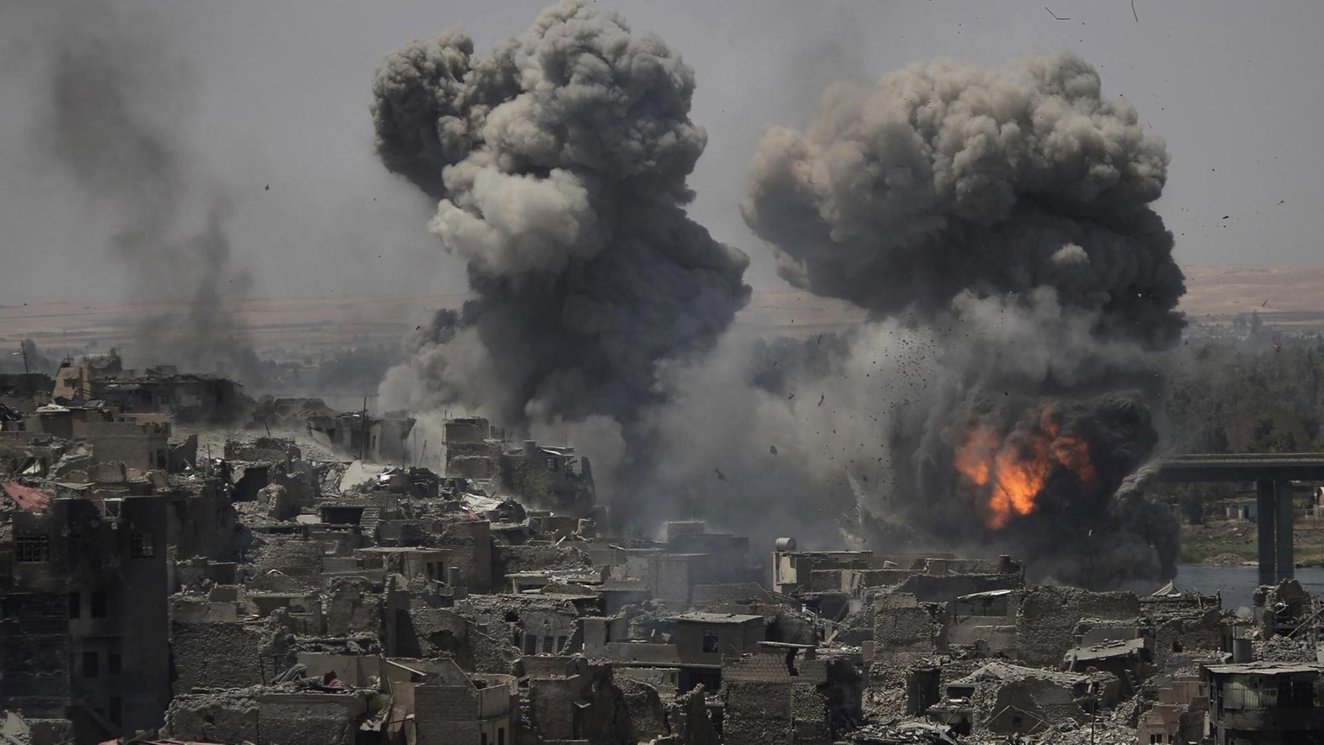 dpatopbilder - Rauch und Explosionen sind am 11.07.2017 nach Luftangriffen auf Stellungen der Terrormiliz Islamischer Staat (IS) in Mossul (Irak) zu sehen. Am Montag hatte der irakische Premierminister Haider al-Abadi die IS-Hochburg im Norden des Landes als vom Islamischen Staat befreit erklärt. Foto: Felipe Dana/AP/dpa +++(c) dpa - Bildfunk+++