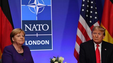 German Chancellor Angela Merkel (L) and US President Donald Trump hold a bilateral meeting on the sidelines of the NATO summit at the Grove hotel in Watford, northeast of London on December 4, 2019. (Photo by Nicholas Kamm / AFP)