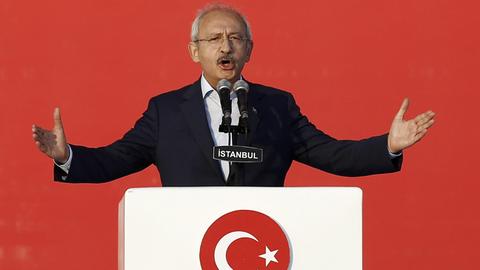 Das Bild zeigt den türkischen Oppositionsführer Kemal Kilicdaroglu, Chef der sozialdemokratischen Partei CHP. Er steht an einem Rednerpult vor rotem Hintergrund.