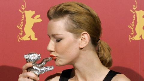 Sandra Hüller küsst den Silbernen Bären, den sie als beste Darstellerin für den Film "Requiem" auf der Berlinale 2006 erhielt.