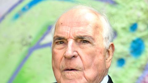 Der ehemalige Bundeskanzler Helmut Kohl (CDU) sitzt am 16.05.2014 in Oggersheim (Rheinland-Pfalz) im Garten seines Wohnhauses vor einem Originalstück der Berliner Mauer.