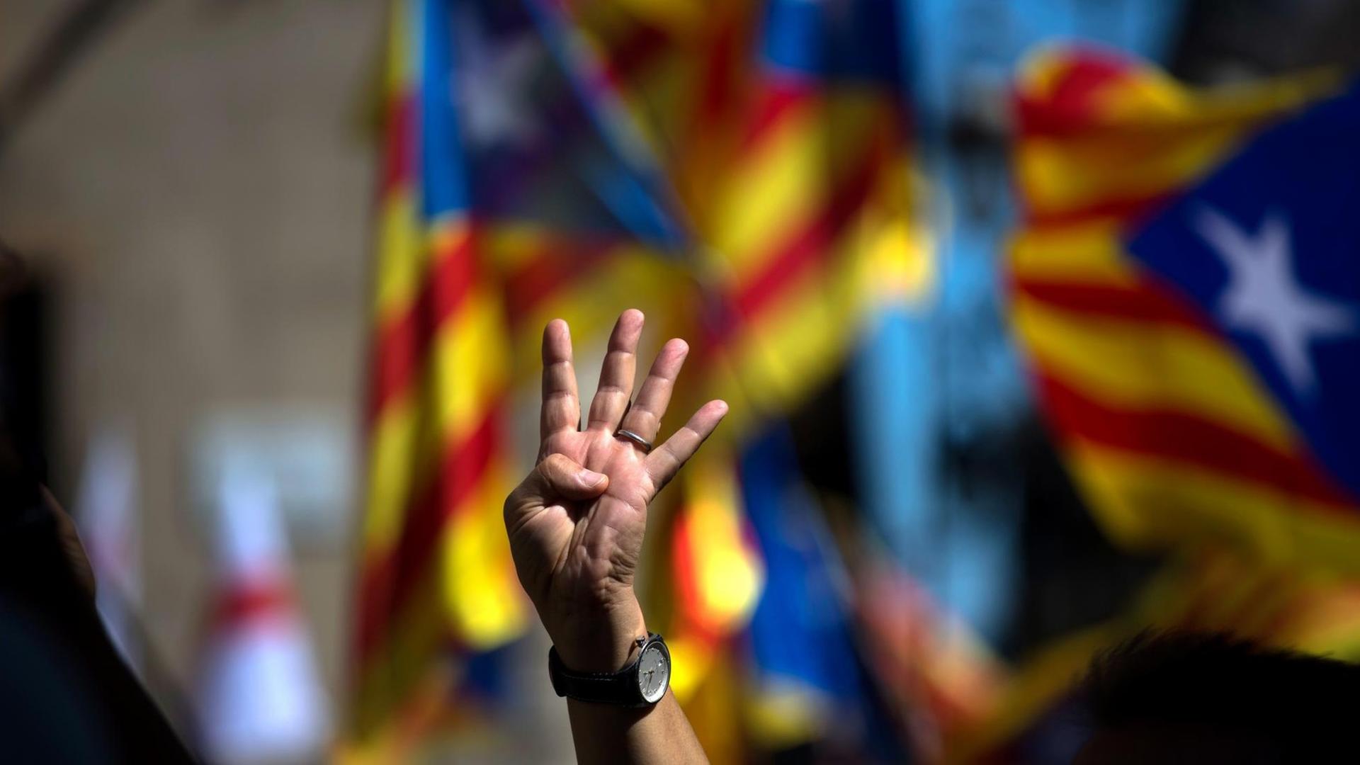Ein Unterstützer der Unabhängigkeitsbestrebungen Kataloniens hält am 16.09.2017 in Barcelona (Spanien) vier Finger als Zeichen für die vier Balken der Estelada-Flagge (der offiziellen Flagge der autonomen spanischen Region Katalonien) hoch, um gegen eine Entscheidung des Verfassungsgerichts zu protestieren, welches die von der Regionalregierung von Carles Puigdemont für den 01.10.2017 ausgerufene Volksbefragung untersagte.