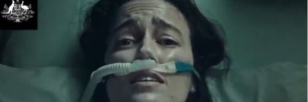 Eine Frau liegt auf einem Krankenhausbett um ringt um Luft.