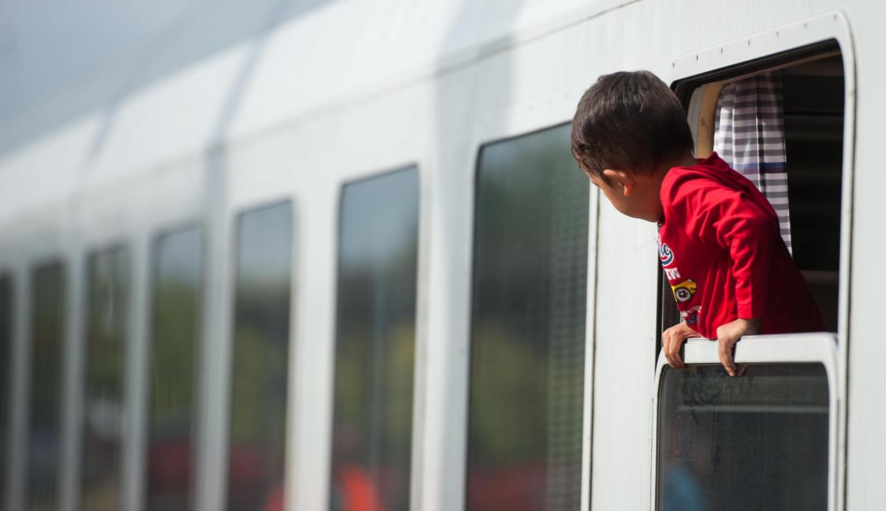 Ein Flüchtlingskind blickt am 13.09.2015 am Bahnhof von Uelzen (Niedersachsen) aus einem ankommenden Zug. Foto: Philipp Schulze/dpa |