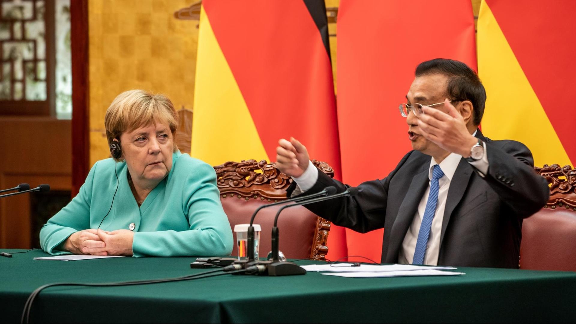 Bundes-Kanzlerin Angela Merkel sitzt neben dem Regierungs-Chef von China. Er heißt Li Keqiang.