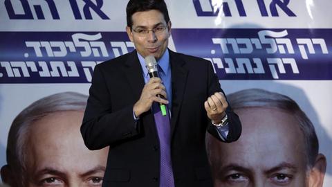 Der rechts-nationale Politiker Danny Danon von der israelischen Likud-Partei wirbt während des Wahlkampfs für Premierminister Benjamin Netanjahu, dessen Porträt auf mehreren Plakaten im Hintergrund zu sehen ist.