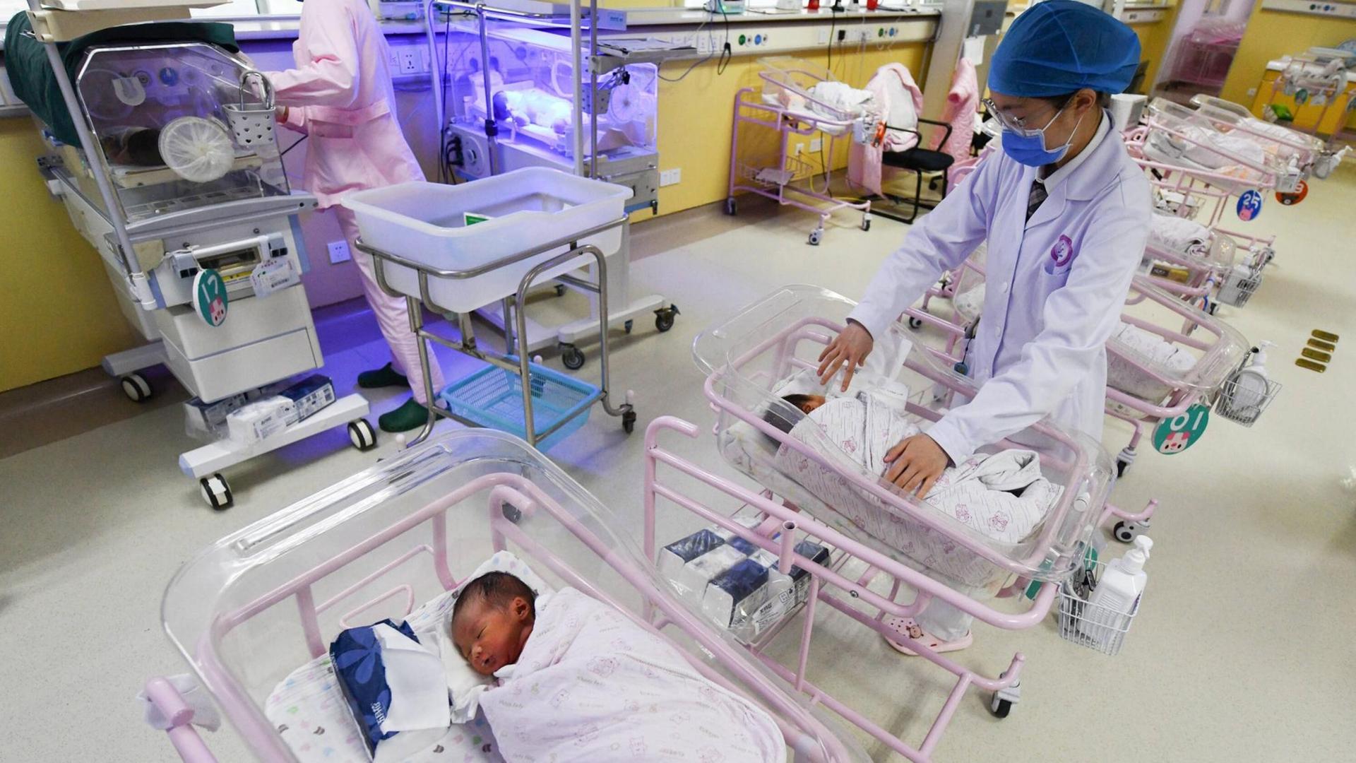 Eine Krankenschwester kümmert sich um ein Baby auf der Neugeborenenstation in Fuyang, Anhui, China, April 2021