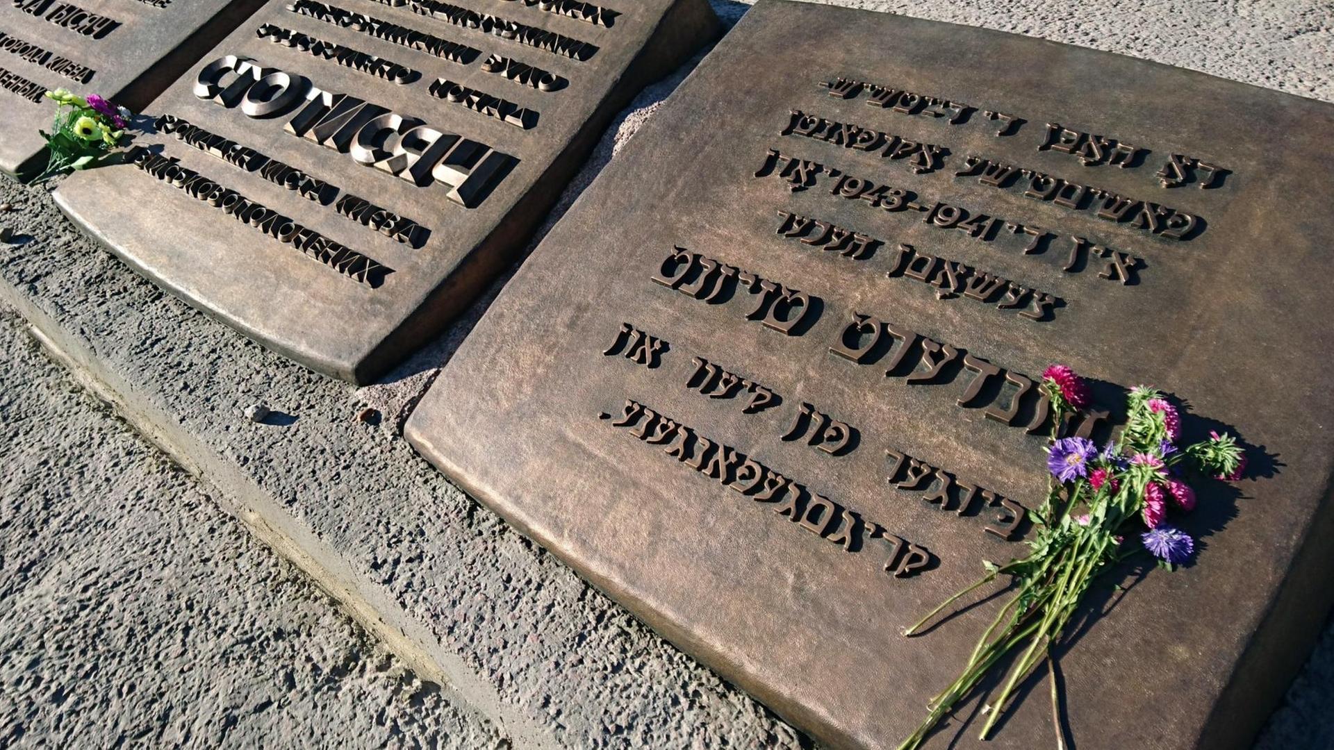 Blumen liegen vor einem 1976 errichteten Denkmal für die während der deutschen Besatzungszeit 1941-1943 in Babi Jar erschossenen "Bürger der Stadt Kiew und Kriegsgefangenen" in Kiew (Ukraine).