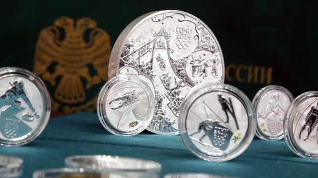 Sotschi-2014-Münzen der Russischen Zentralbank stehen und liegen auf einem Tisch.