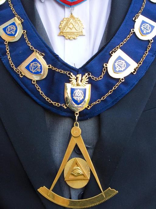 Detailansicht des goldenen Ordensschmucks eines Großmeisters der Freimaurer mit Freimaurersymbolen.