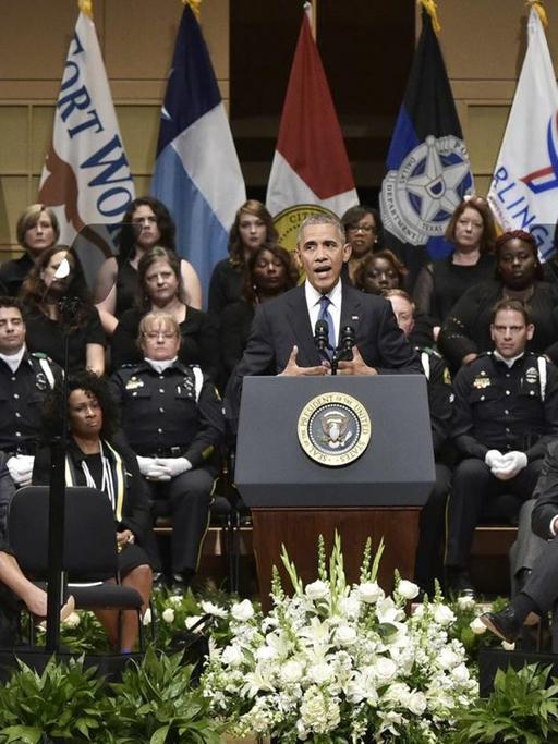 US-Präsident Barack Obama spricht bei dem Trauergottesdienst in Dallas. Hiter ihm sitzen zahlreiche Polizisten.