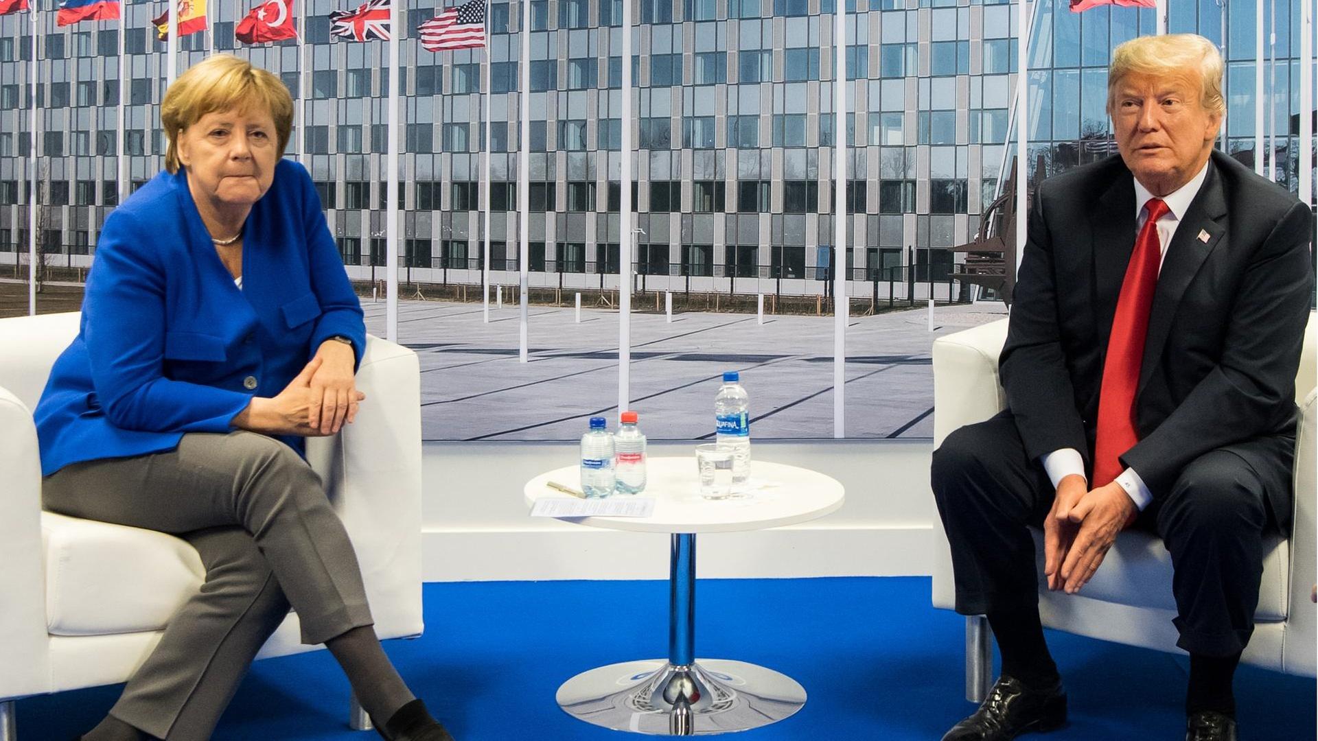 Bundeskanzlerin Angela Merkel und US-Präsident Donald Trump sprechen am Rande des Nato-Gipfels miteinander.