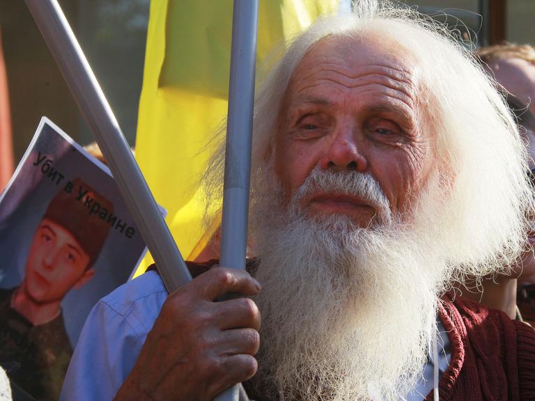 "Getötet in der Ukraine", heißt es auf dem Foto eines Soldaten, das Demonstranten halten.