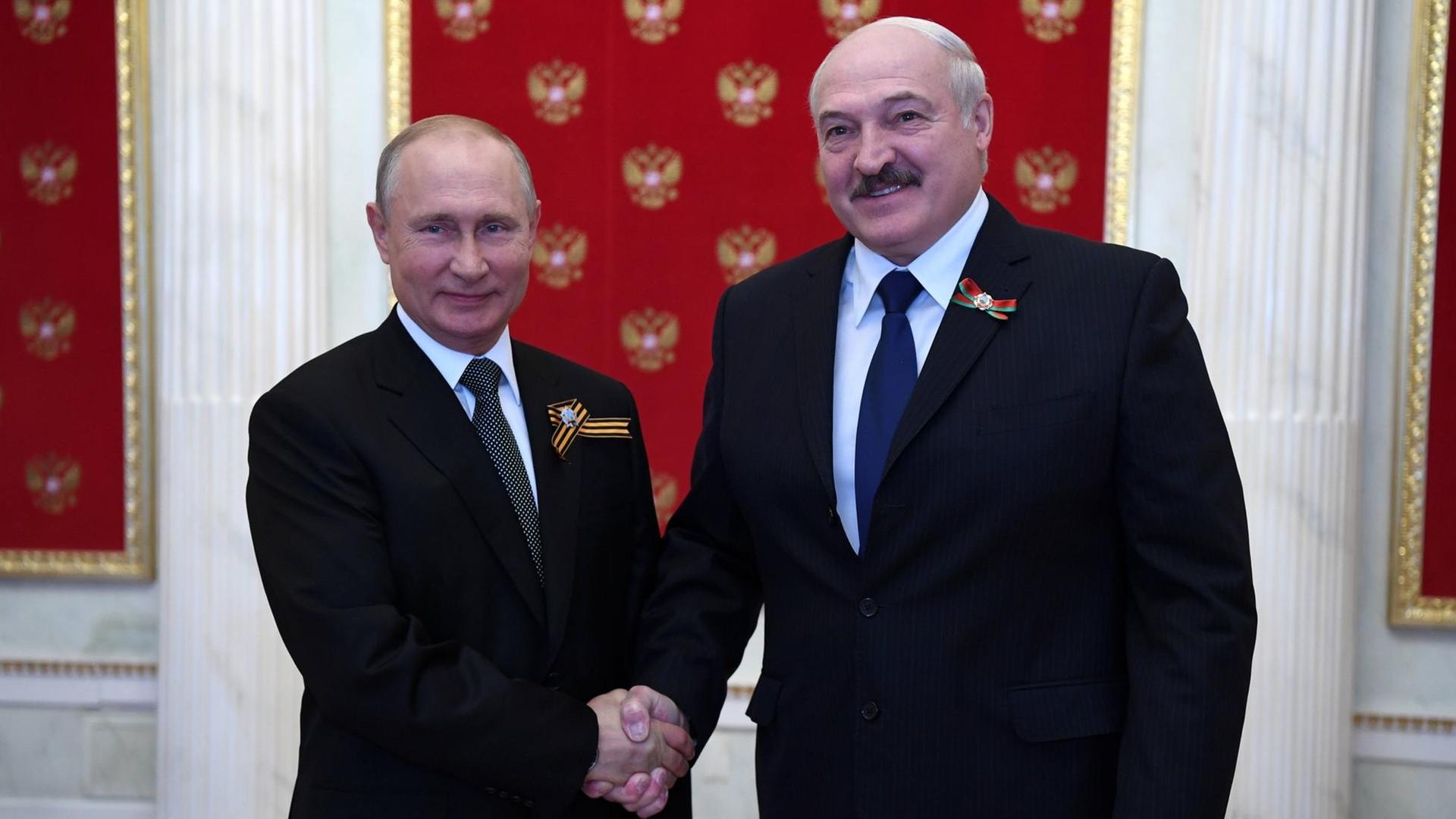 Der russische Präsident Wladimir Putin und Präsident Alexander Lukaschenko geben sich im Kreml die Hand.