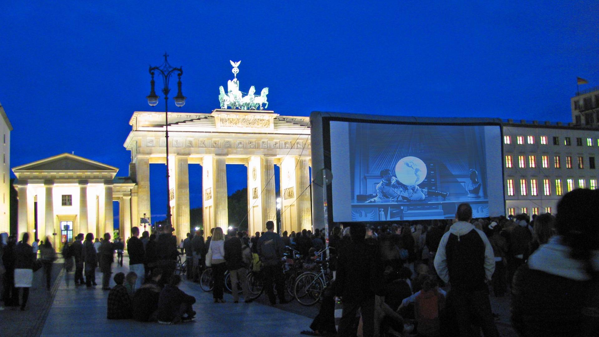 Am Brandenburger Tor in Berlin wird "Der große Diktator" von Charlie Chaplin gezeigt.