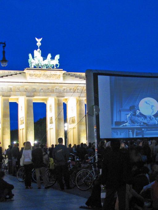 Am Brandenburger Tor in Berlin wird "Der große Diktator" von Charlie Chaplin gezeigt.