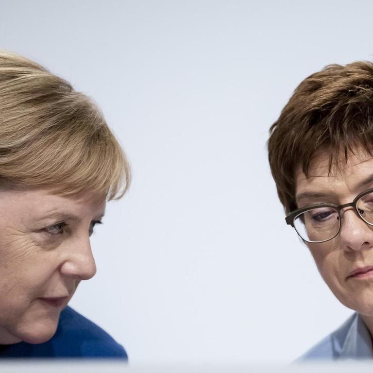 Bundeskanzlerin Angela Merkel (CDU, l), und Annegret Kramp-Karrenbauer, Bundesministerin der Verteidigung und CDU-Vorsitzende sitzen nebeneinander.