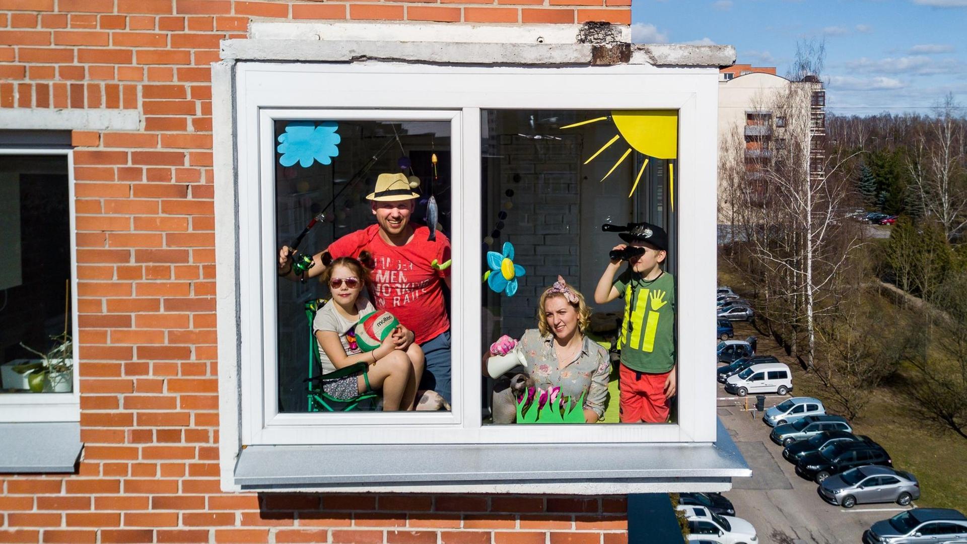Ein Familie schaut aus einem Fenster nach draußen.