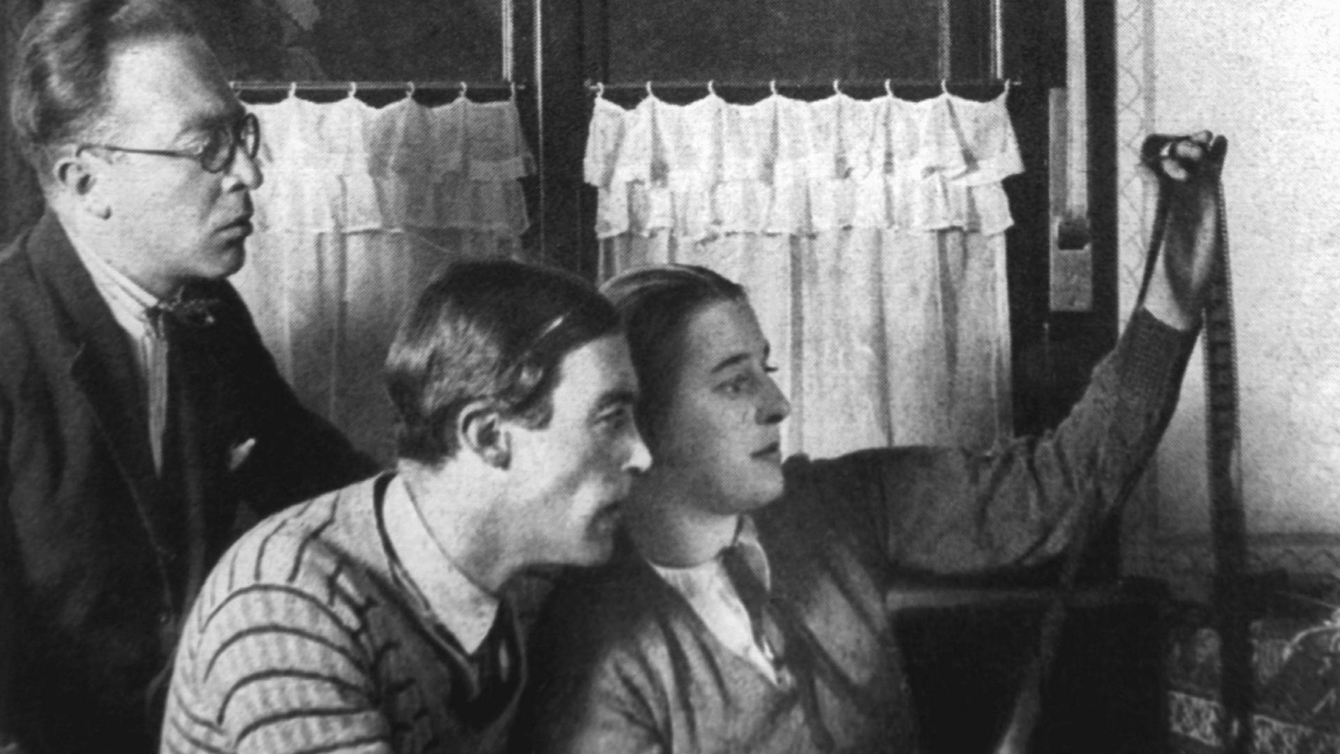 Die Filmpioniere Lotte Reiniger (r) und Walter Ruttmann (M) bei der Betrachtung eines Filmstreifens. Person links nicht identifiziert. 