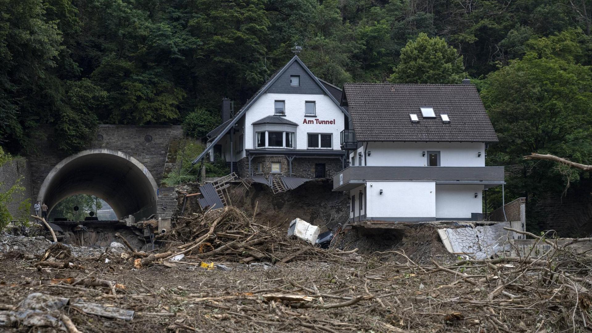 Ein Haus mit der Beschriftung "Am Tunnel", von dem ein großer Teil des Unterschosses und des Hanges, auf dem es steht, weggeschwemmt wurde.