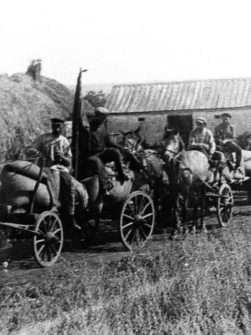 In einem ukrainischen Dorf bei Charkiw werden 1932 im Auftrag der Bolschewiken mit Pferdewagen Lebensmittel abtransportiert.