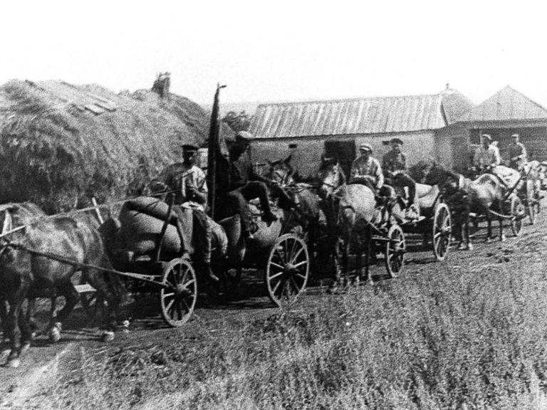 In einem ukrainischen Dorf bei Charkiw werden 1932 im Auftrag der Bolschewiken mit Pferdewagen Lebensmittel abtransportiert.