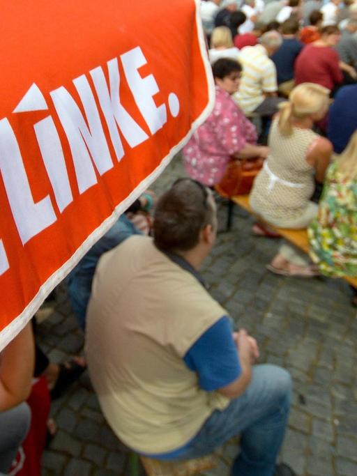 Schweriner Bürger hören in Schwerin bei einer Wahlkampfveranstaltung der Partei Die Linke einer Rede zu.
