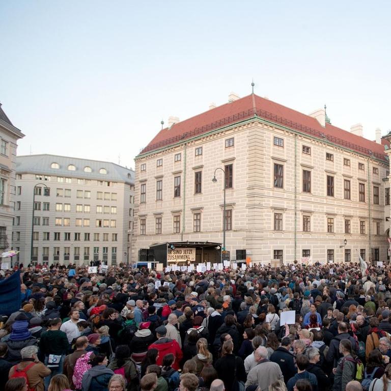 04.10.2018, Österreich, Wien: Menschen nehmen an einer Demonstration auf dem Ballhausplatz teil. Mehrere Tausend Demonstranten haben in Österreich gegen die rechtskonservative Regierung protestiert. Die Menge am Ballhausplatz vor dem Bundeskanzleramt in Wien skandierte am Donnerstagabend den 04.10.2018 Parolen gegen Rassismus und Sozialabbau und warnte vor einem Schwund der Demokratie.