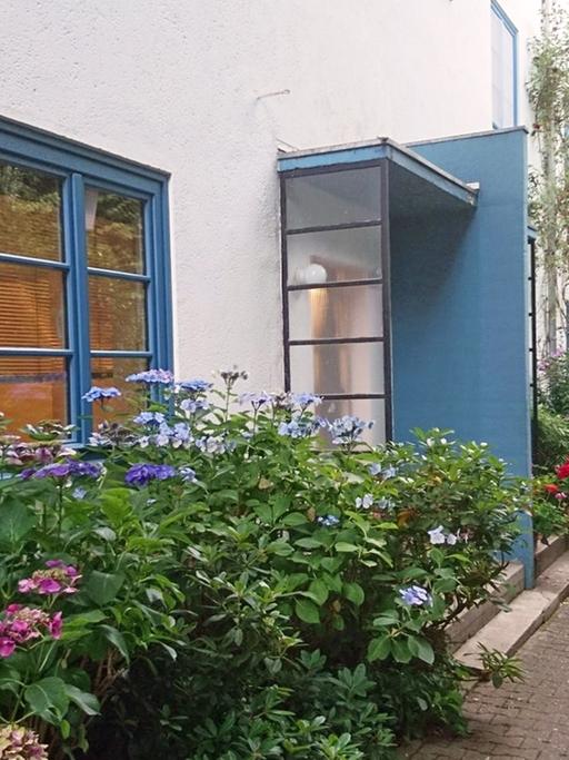 Hauseingang mit blauen Tür- und Fensterahmen in der Ernst May Siedlung Höhenblick in Frankfurt