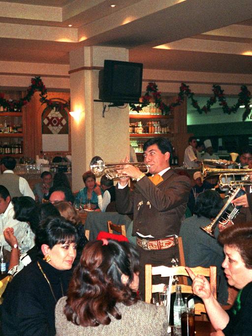 Ausgelassene Stimmung in der Cantina "La numero uno", einer der größten ihrer Art in Mexiko-Stadt. Zur musikalischen Untermalung spielt eine typisch mexikanische Bläsergruppe, die sogenannten "Mariachis". Rund 1000 dieser Trink- und Eßlokale gibt es allein in der mexikanischen Hauptstadt, und noch viele Tausend mehr in der Provinz. Aufgenommen am 27. November 1996.