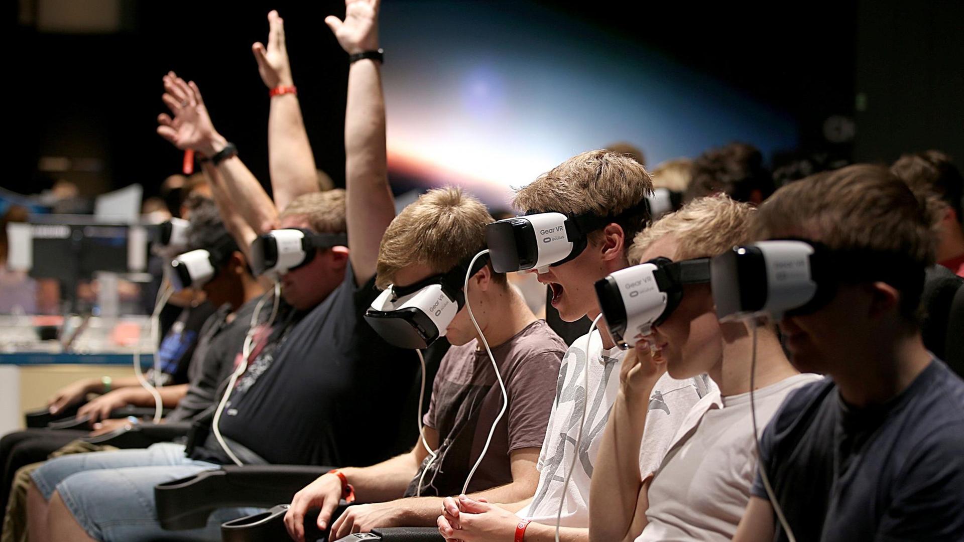 Besucher der Gamescom machen am 23.08.2017 in Köln mit einer Gear-VR Brille eine Achterbahnfahrt.