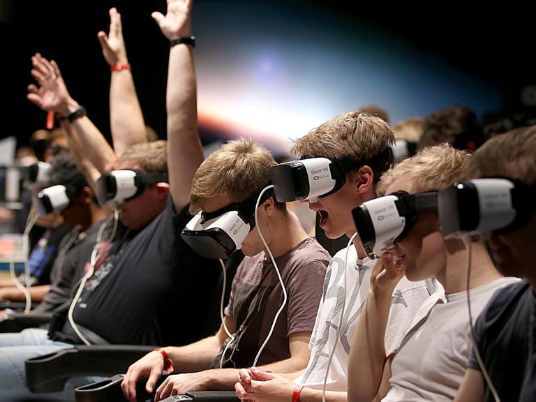 Besucher der Gamescom machen am 23.08.2017 in Köln mit einer Gear-VR Brille eine Achterbahnfahrt.
