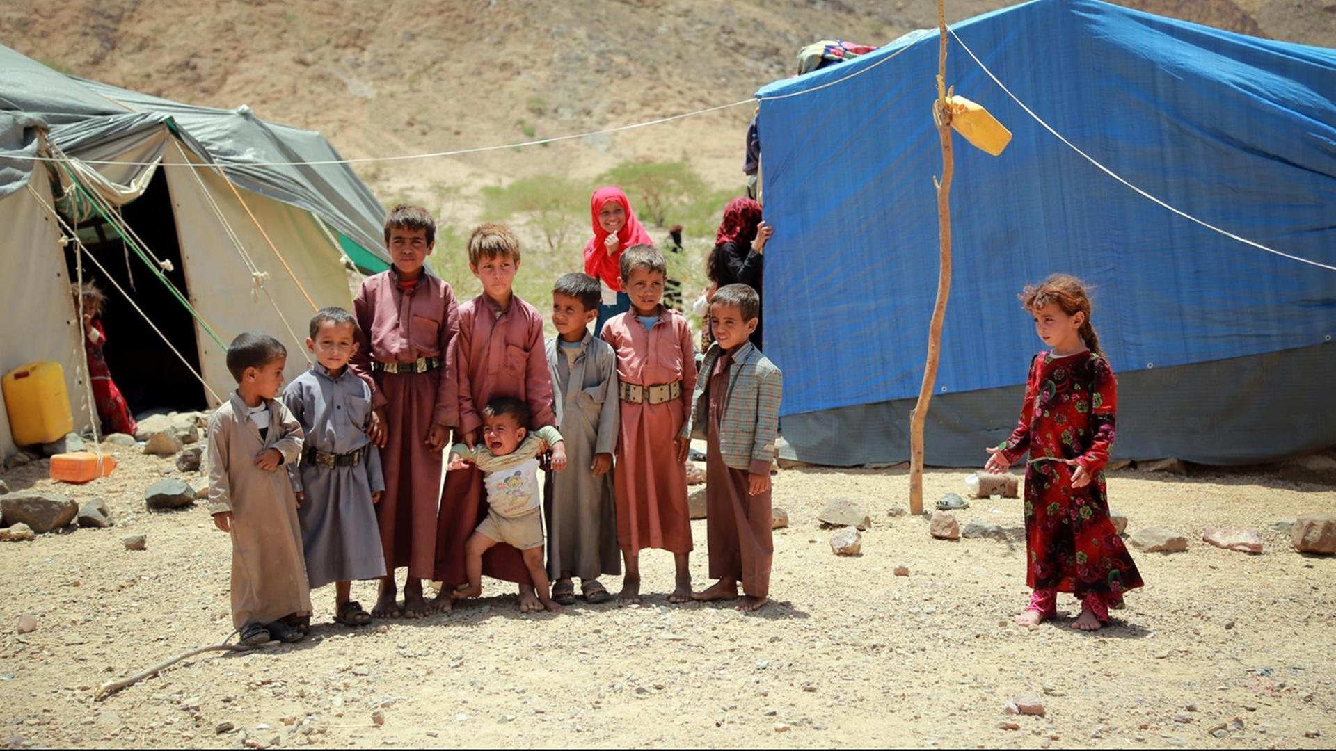 Kinder aus dem Jemen stehen in einem provisorischen Lager für Binnenflüchtlinge neben einem Zelt, nachdem sie ihre Heimatregion Nehm verlassen mussten.