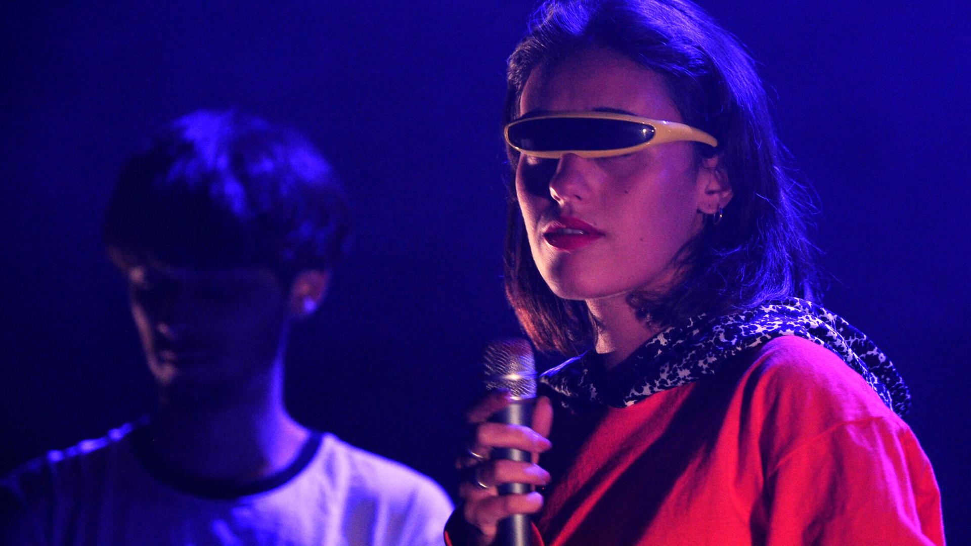 Sängerin und Mitglied der französischen Rockband Agar Agar Clara Cappagli steht im Juli 2017 mit einer futuristischen Sonnenbrille auf einer Bühne.