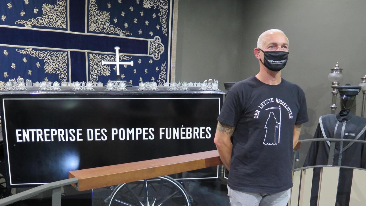Porträt Erich Traxler mit Mundschutz und einem T-Shirt, auf dem steht: "Der letzte Reiseleiter".