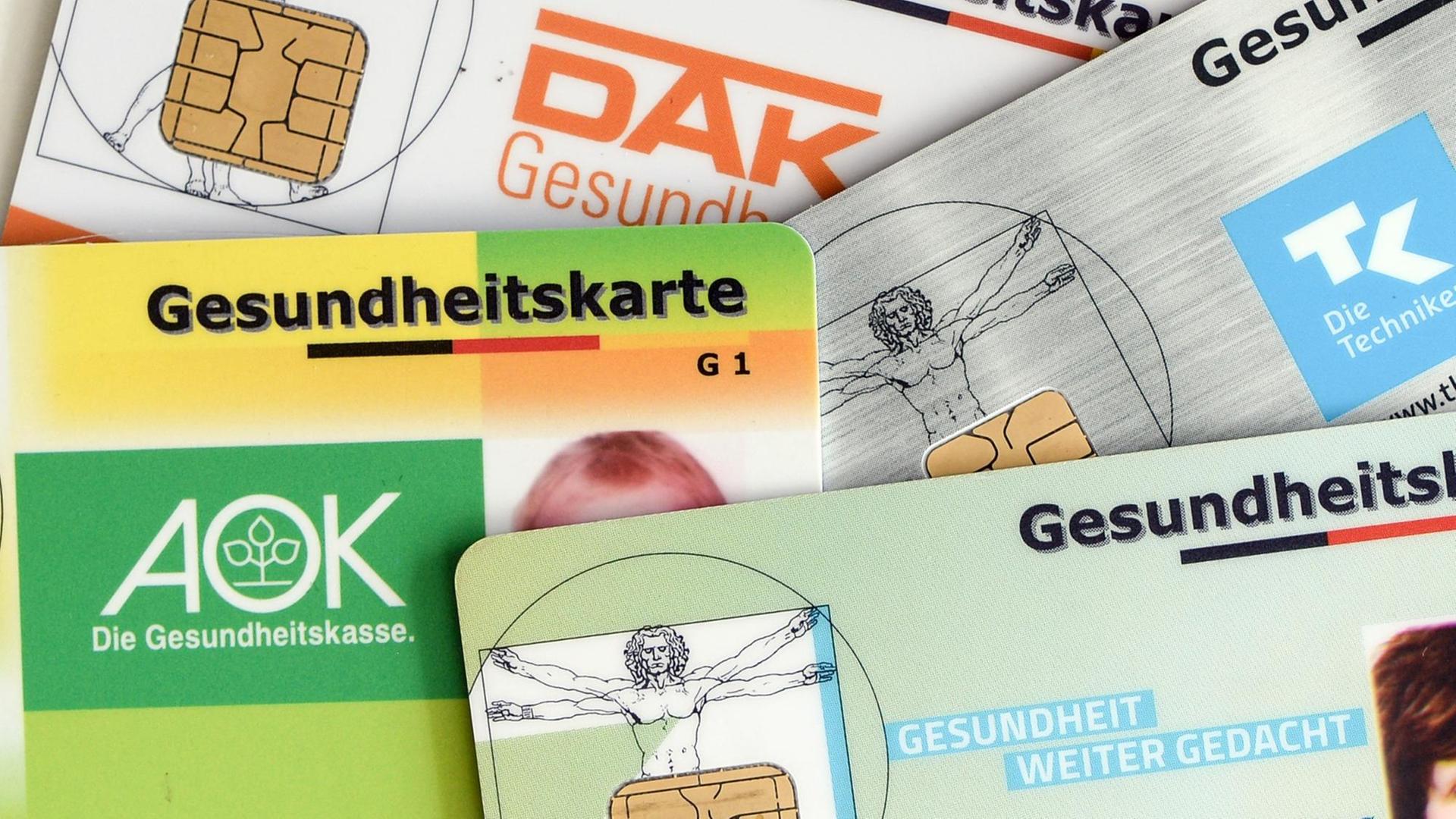 Versichertenkarten (AOK, TK, BarmerGEK, DAK) liegen übereinander.