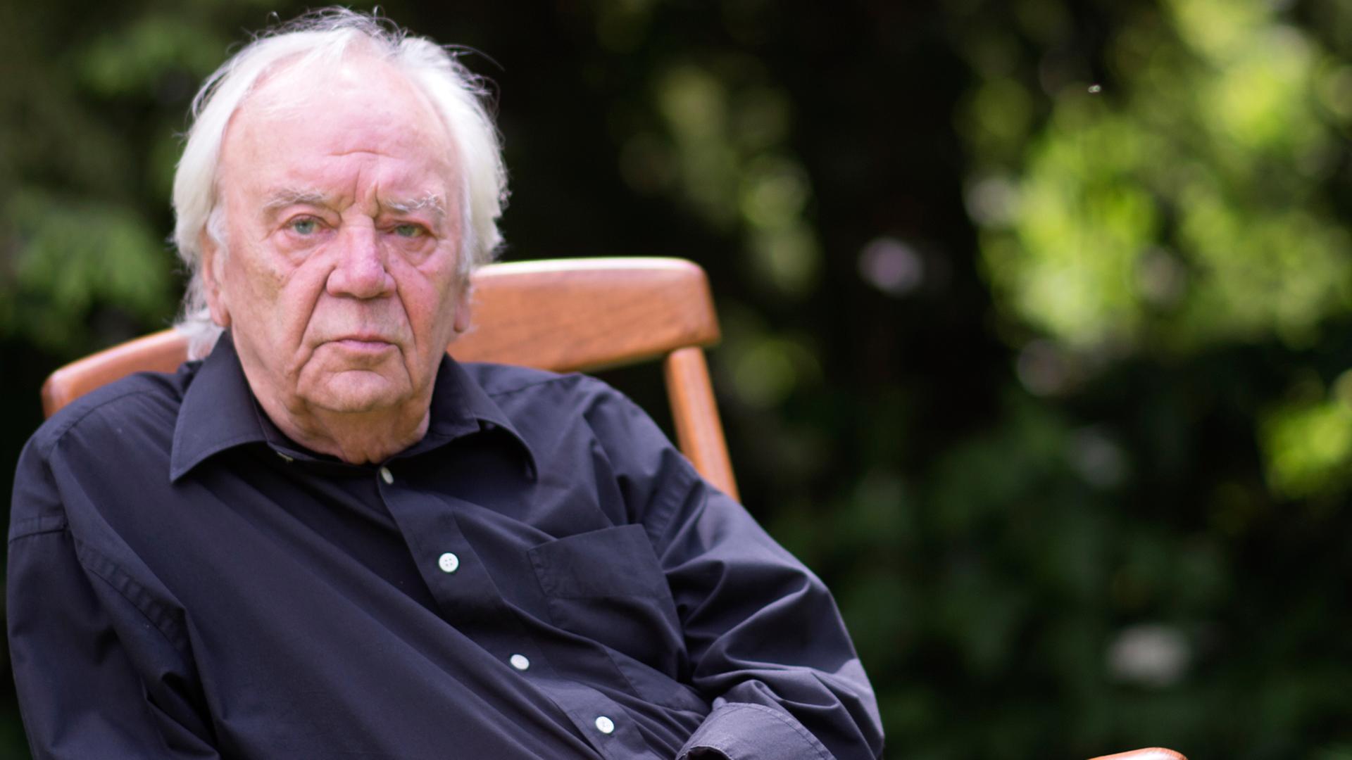 Der Schriftsteller Jürgen Becker posiert am 30.05.2014 in seinem Garten in Odenthal (Nordrhein-Westfalen).