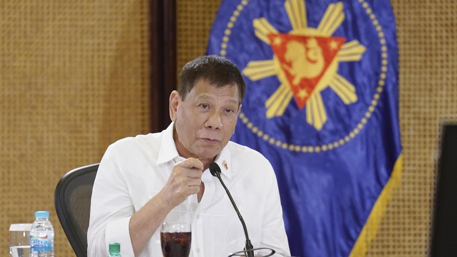 Staatschef Rodrigo Duterte bei einem Treffen mit der philippinischen Infektionschutz-Agentur im Präsidentenpalast in Manila, vor sich ein Mikro und ein Getränk