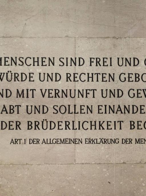 Der erste Artikel der Menschenrechtserklärung auf einer Mauer des Parlaments in Wien, Österreich.