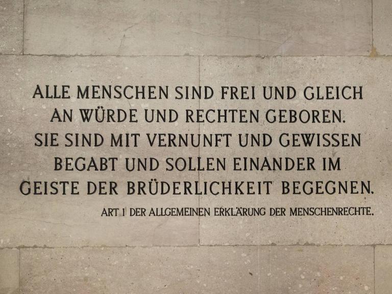 Der erste Artikel der Menschenrechtserklärung auf einer Mauer des Parlaments in Wien, Österreich.