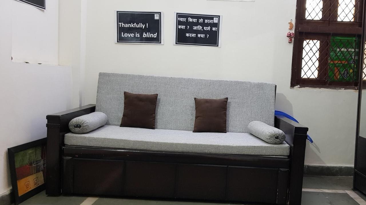 Ein helles Sofa mit zwei braunen Kissen steht in einem Büro.