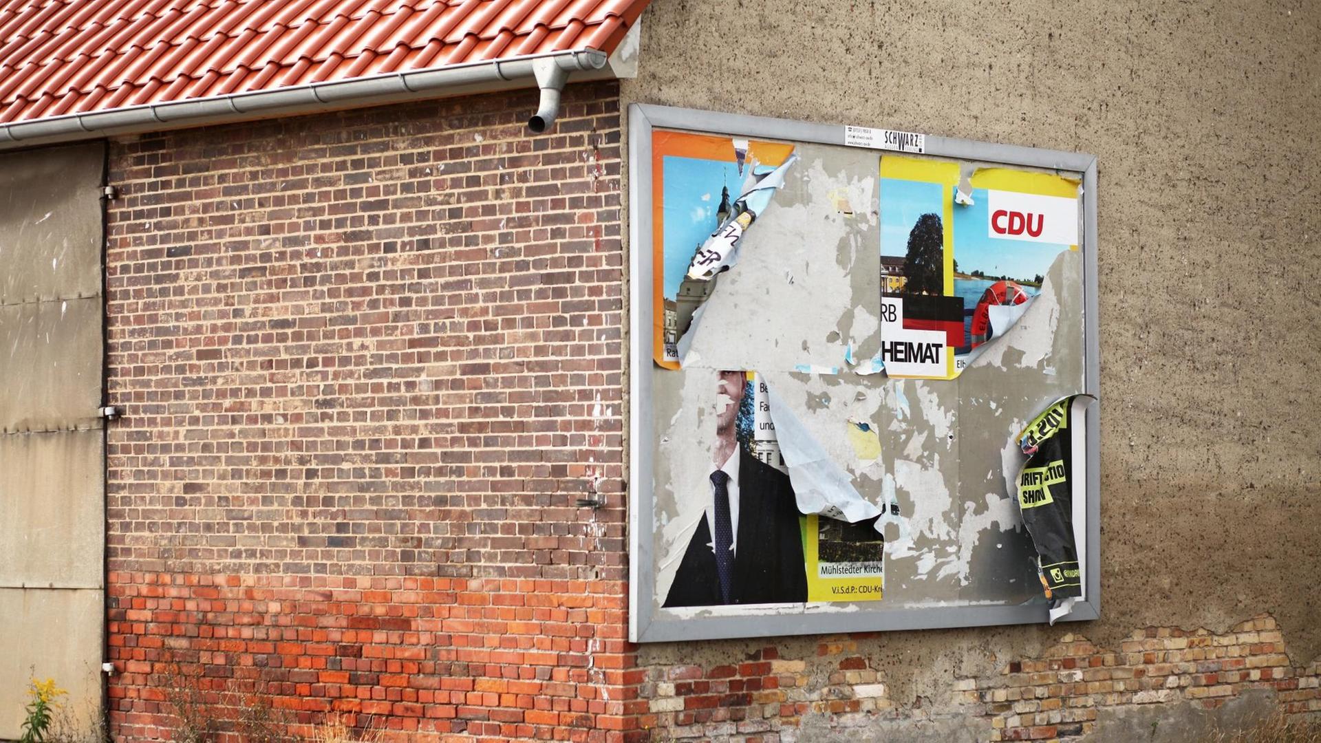 Ein abgerissenes Wahlplakat der CDU hängt an der Wand eines leerstehenden Hauses im Stadttreil Griesen. Auf den verbliebenen Fetzen sind noch der Parteiname und das Wort "Heimat" zu lesen.