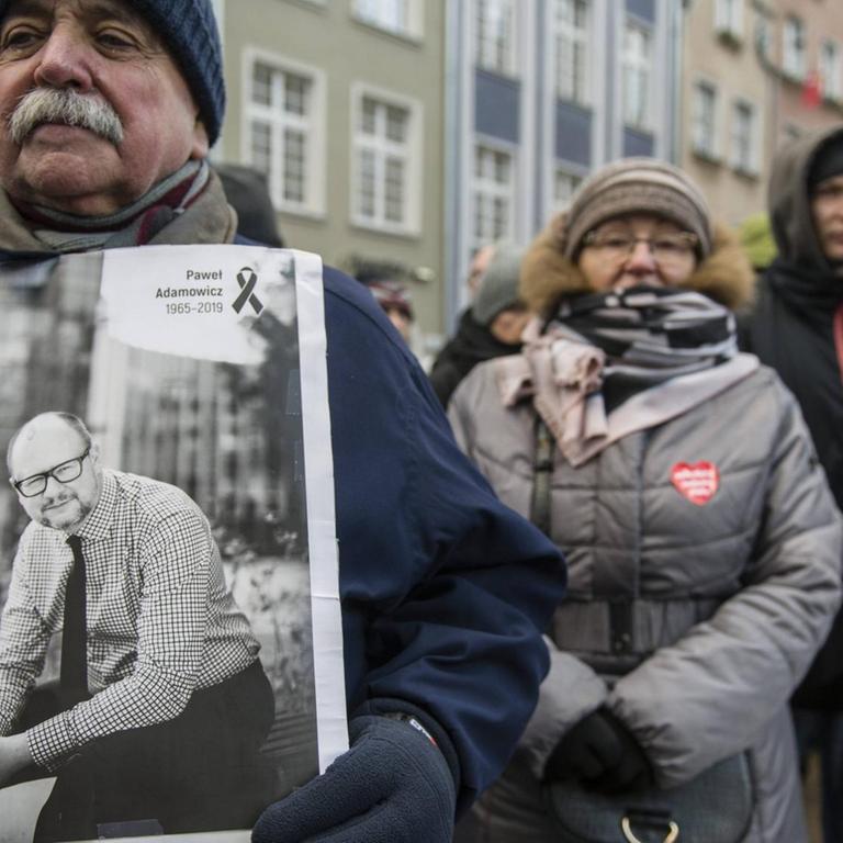 Ein trauernder Mann in Danzig hält ein Bild des getöteten Bürgermeisters Pawel Adamowicz.