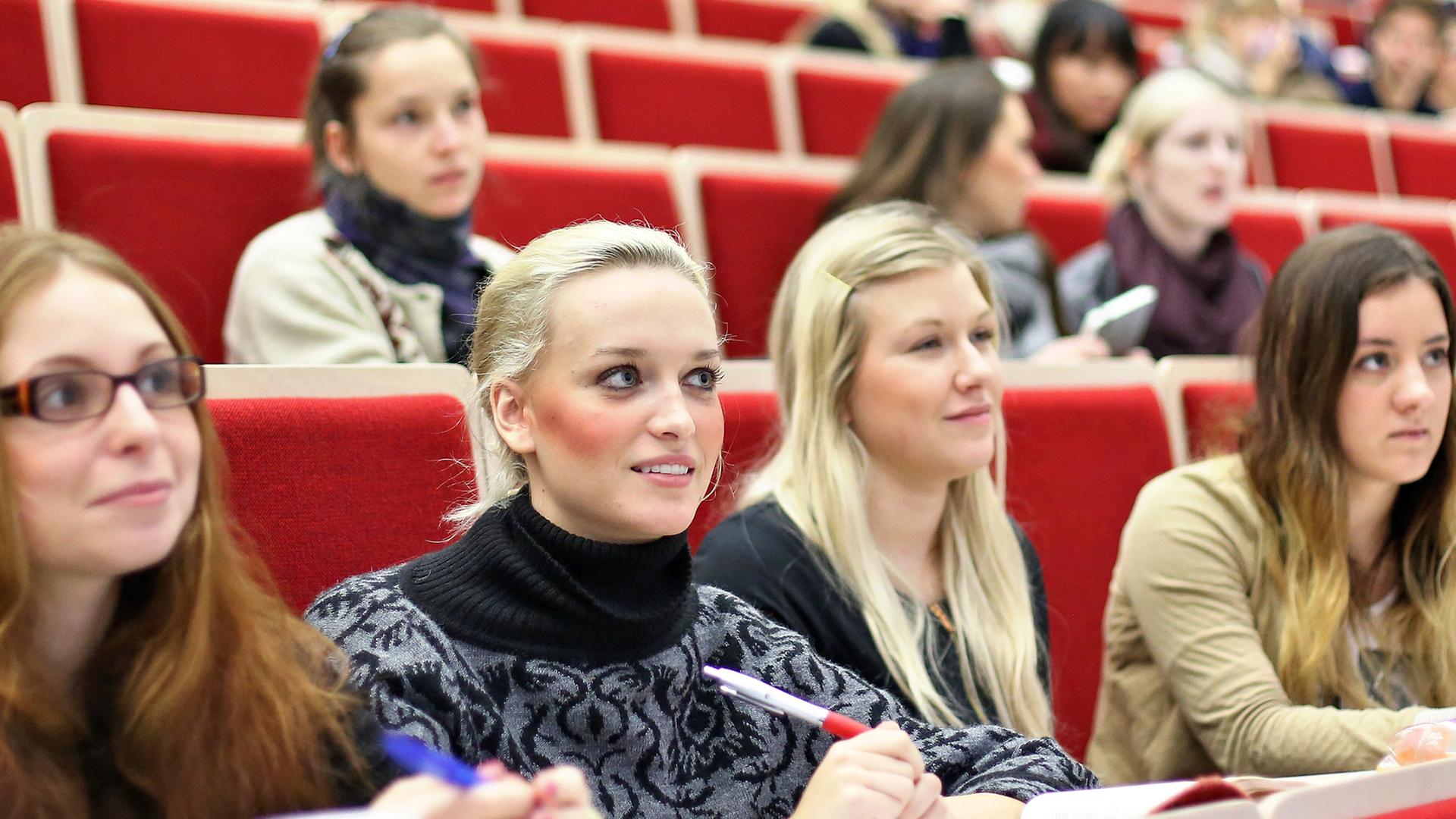 Studentinnen sitzen in einem Hörsaal