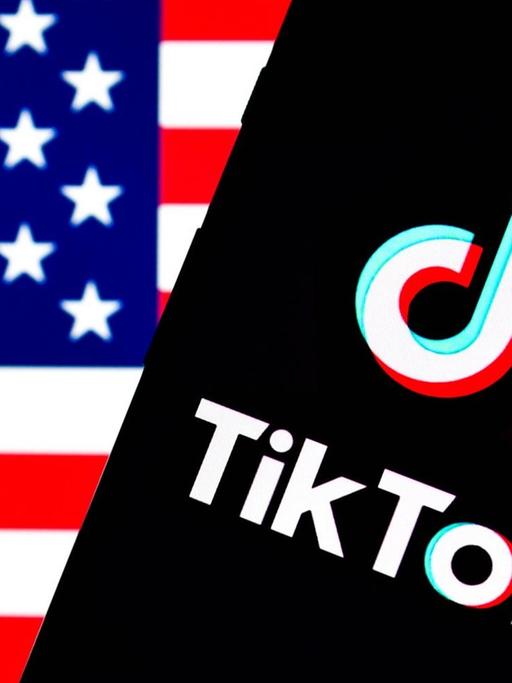 Auf dem Bild ist ein Smartphone mit dem TikTok-Logo vor einer US-Flagge zu sehen