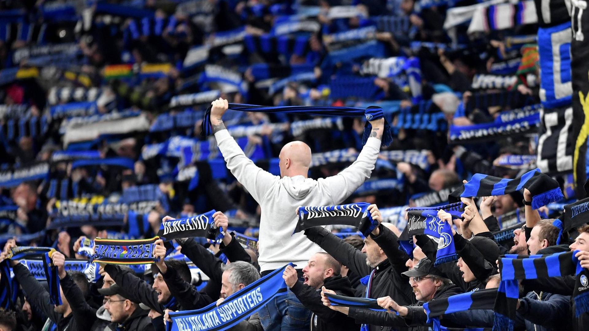 Anhänger des italienischen Erstligisten Atalanta Bergamo halten im Stadion Schals mit der Aufschrift ihres Vereins in die Höhe. Anhänger des italienischen Erstligisten Atalanta Bergamo halten im Stadion Schals mit der Aufschrift ihres Vereins in die Höhe.