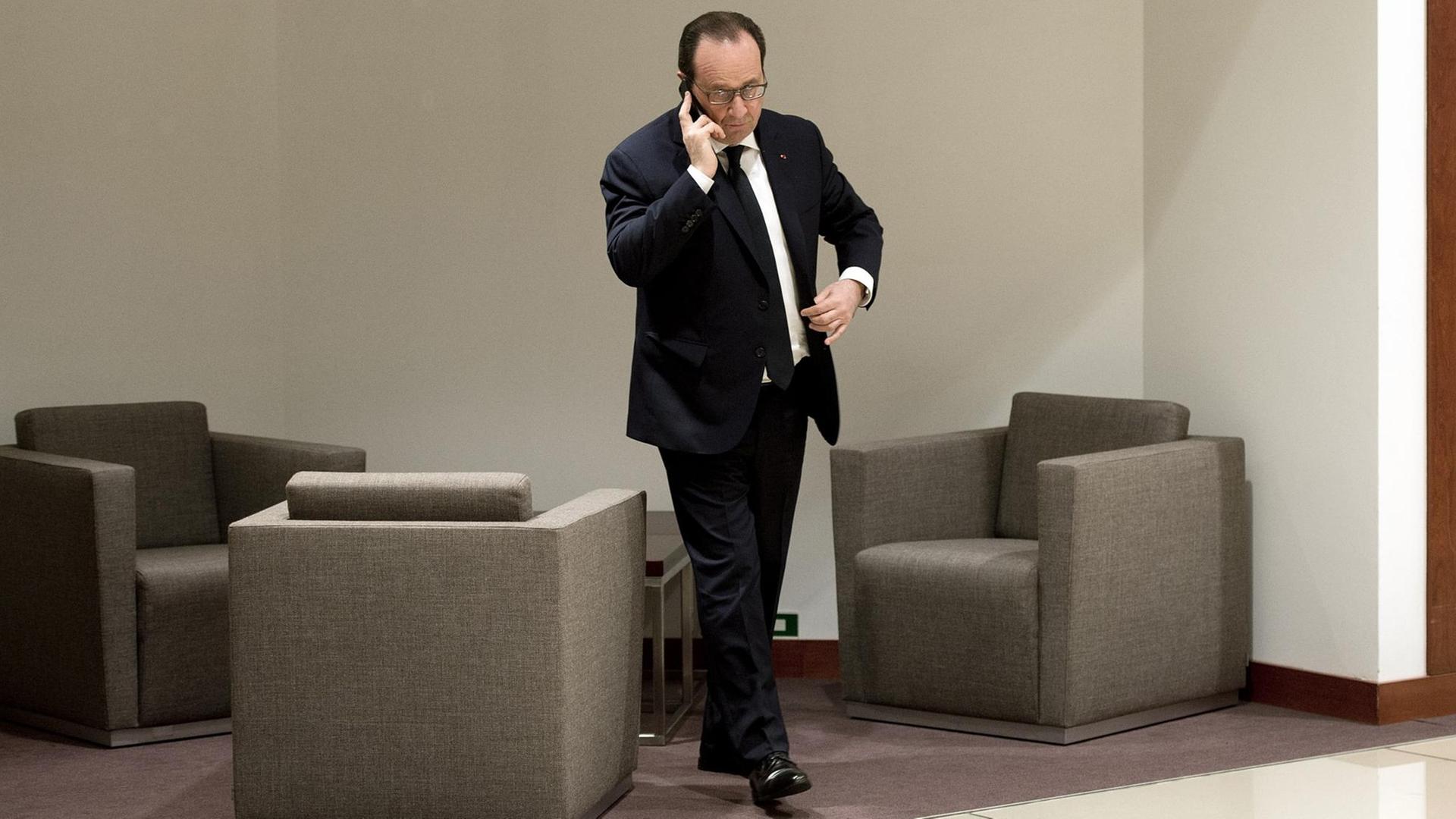 Der französische Präsident Hollande telefoniert am Rande eines EU-Gipfels in Brüssel mit seinem Handy.