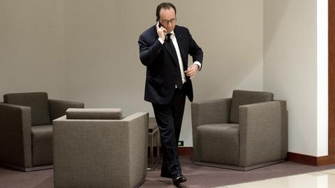 Der französische Präsident Hollande telefoniert am Rande eines EU-Gipfels in Brüssel mit seinem Handy.