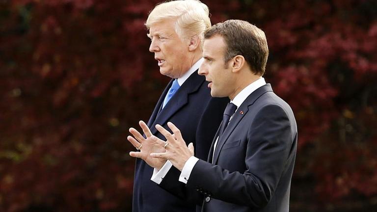 Trump und Macron schreiten durch den Park vor dem Weißen Haus