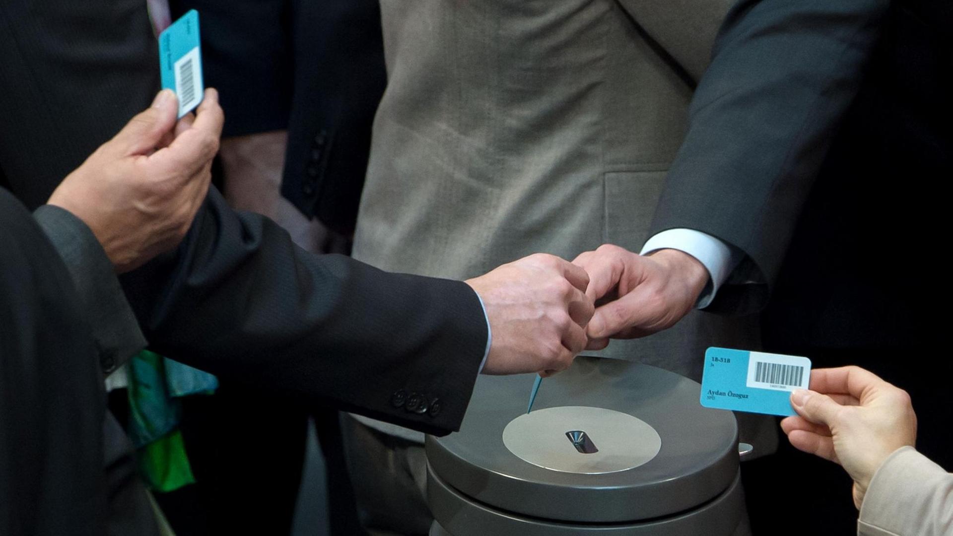 Abgeordnete werfen am 27.02.2015 im Bundestag in Berlin ihre Stimmkarten in eine Wahlurne.